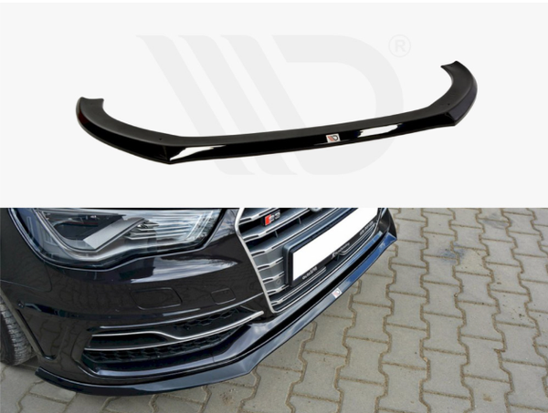 A black car lip spoiler is shown separately and installed on a black car's front bumper, parked on a cobblestone surface.