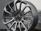 A modern alloy wheel stands upright, displaying intricate split-spoke design. Center hub bearing the text 