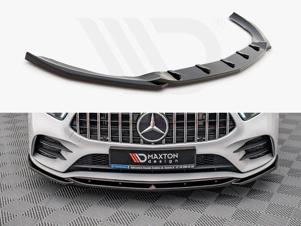 A black car front splitter is displayed; it enhances the aerodynamics of a white Mercedes-Benz with a prominent grille. A sign reads “Maxton design” on the bumper.