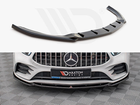 A black car front splitter is displayed; it enhances the aerodynamics of a white Mercedes-Benz with a prominent grille. A sign reads “Maxton design” on the bumper.