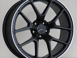 A black alloy wheel with a silver Mercedes logo, features the text 