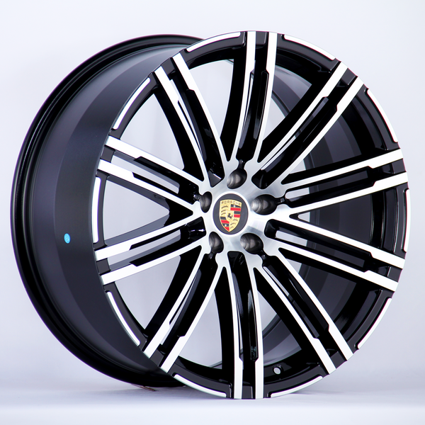 A black and silver alloy wheel with a multi-spoke design featuring the Porsche logo at the center, displayed against a plain white background.