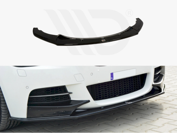 A black car front splitter sits on a white surface. Below, it's installed on a white car parked on a cobblestone driveway, enhancing aerodynamics and aesthetics.