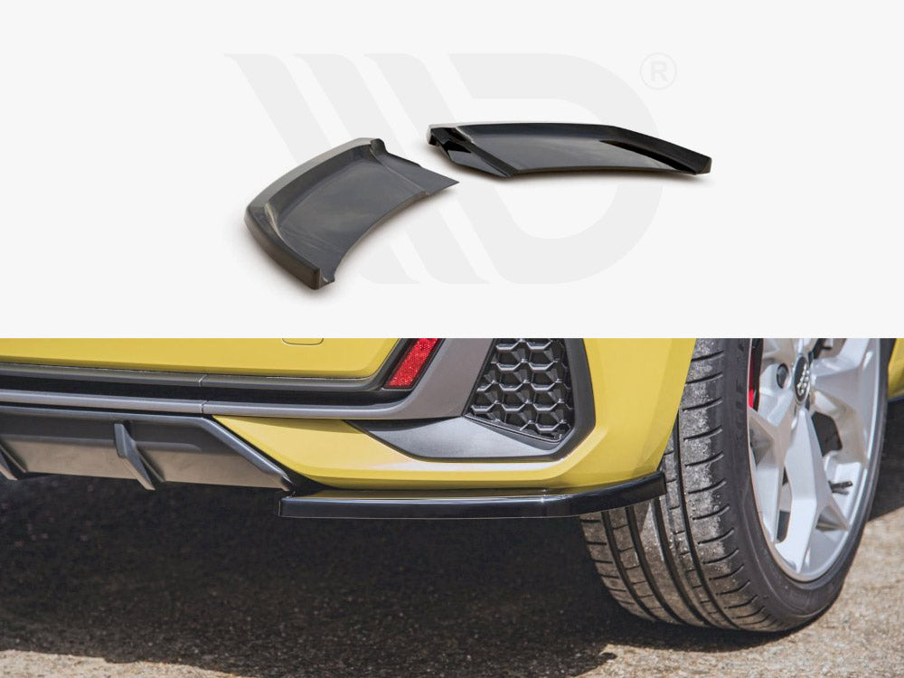 Car rear bumper with two angular black attachments lying detached. The yellow vehicle is parked on asphalt, showcasing silver wheels and a honeycomb-patterned section. Partial logo watermark in the background.