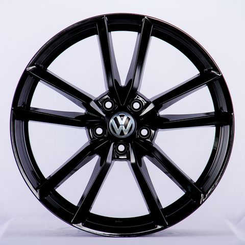 A shiny black, multi-spoke alloy wheel featuring a central Volkswagen logo, displayed against a plain white background.