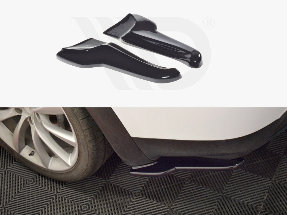 Black automotive mud flaps are displayed; one is installed on a white car's wheel arch near a tire, while the other is shown separately. The background features a textured black mat.