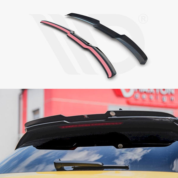 Car roof spoiler components displayed above and installed on a yellow vehicle's rear window. The background shows a building with a "Maxton Design" sign, partially visible.