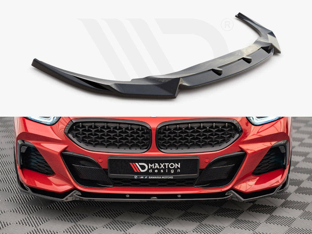 A black car front splitter, designed to enhance aerodynamics, is displayed above a red car's front bumper featuring a matching splitter. The license plate reads "MAXTON DESIGN."