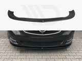 A black car front lip spoiler is shown both separately and installed on a dark-colored car, enhancing its aerodynamics. The car is parked on a stone-paved area.