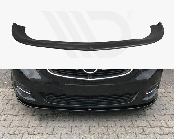 A black car front lip spoiler is shown both separately and installed on a dark-colored car, enhancing its aerodynamics. The car is parked on a stone-paved area.