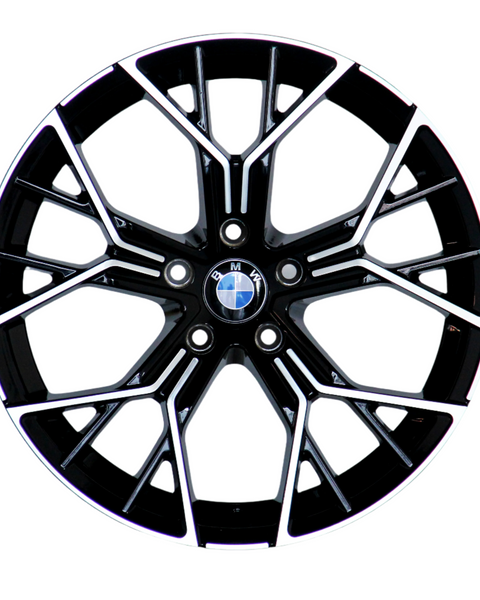 A black alloy wheel with intricate silver spokes and a central BMW logo, resting against a white background.