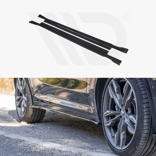 Two black metal strips are positioned horizontally above an image of a car's side, showing wheels and a reflective body, parked on a road with grass nearby.