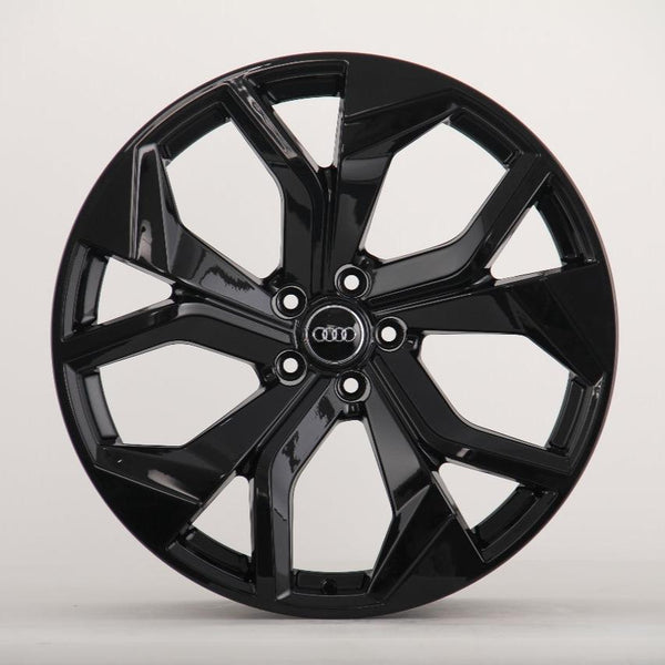 A glossy black car wheel with multiple spokes featuring the Audi logo at its center, displayed against a plain white background.