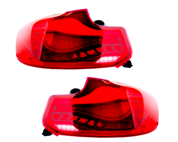 Two red car taillights are displayed side by side on a white background, showcasing their curved design and internal light bulb structure, indicating automotive components.