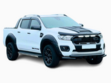A white pickup truck with black accents is parked on a white background. It features bold, aggressive styling with flared wheel arches and sporty side steps. Text: 
