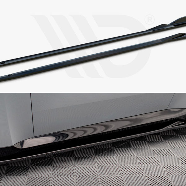 Two black side skirts, shown separately and installed on a car with a gray body, resting on a checkered floor. The skirts enhance the car's aerodynamic appearance.