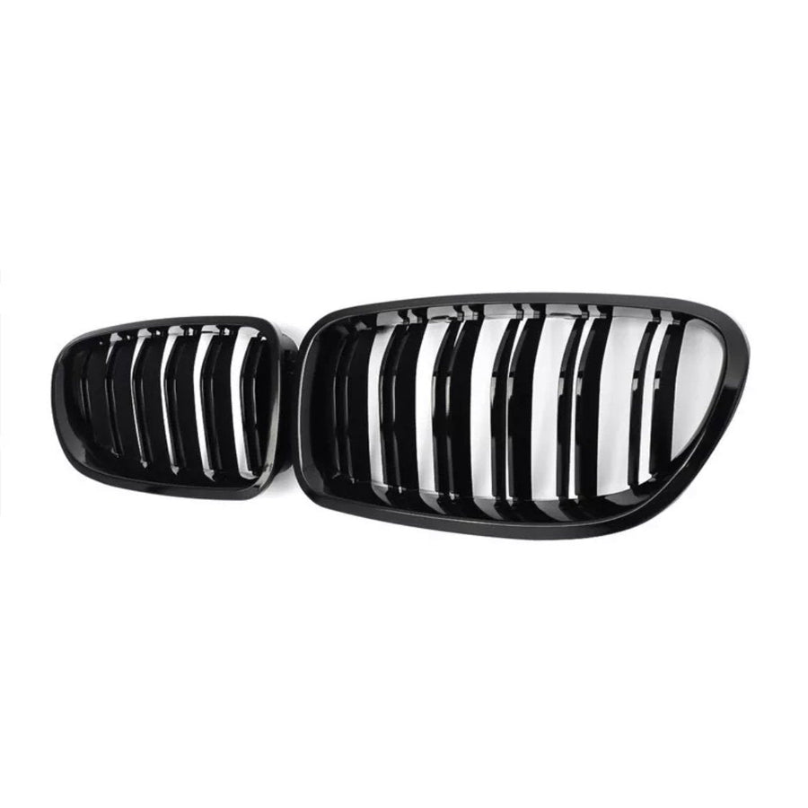 A pair of black car grilles with vertical slats, positioned side by side, set against a plain white background.