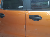 Orange car doors with black handles are closed, reflecting nearby objects. A sign with text is visible through the window.