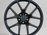 A black alloy wheel with a Mercedes logo in the center and 