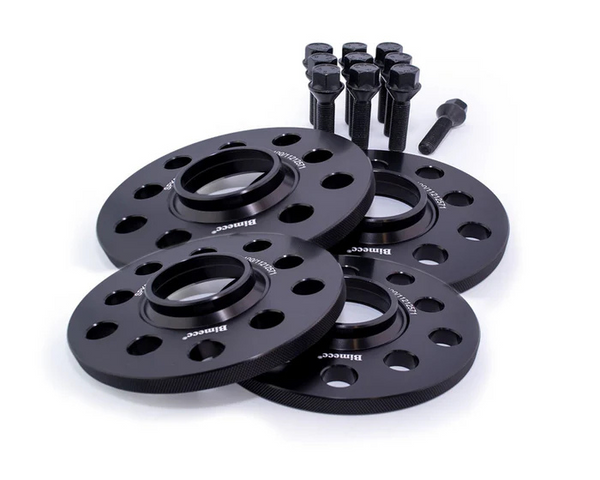 Four black wheel spacers with multiple holes, labeled "Billettec," are arranged in front of several black bolts, placed on a plain white background.
