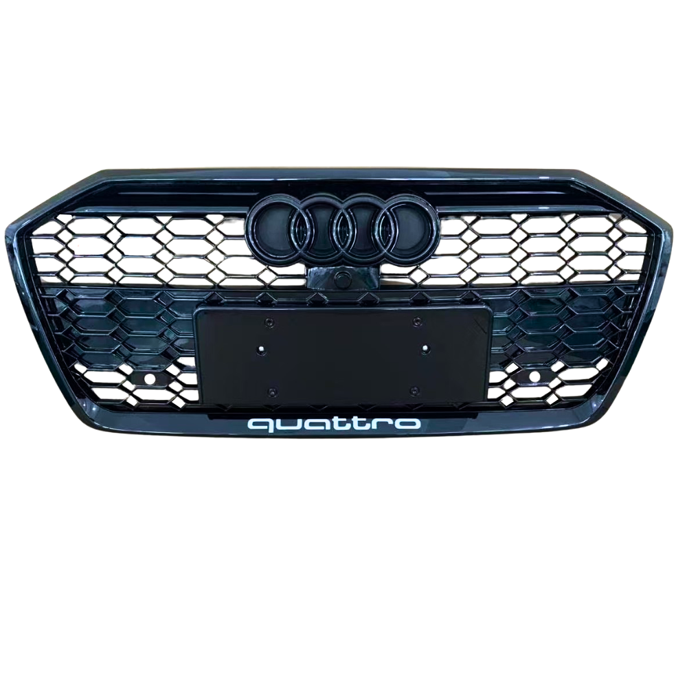 A front car grille displays the Audi logo with four rings and a honeycomb pattern. Below, "quattro" text is located. The background is plain, emphasizing the grille design.