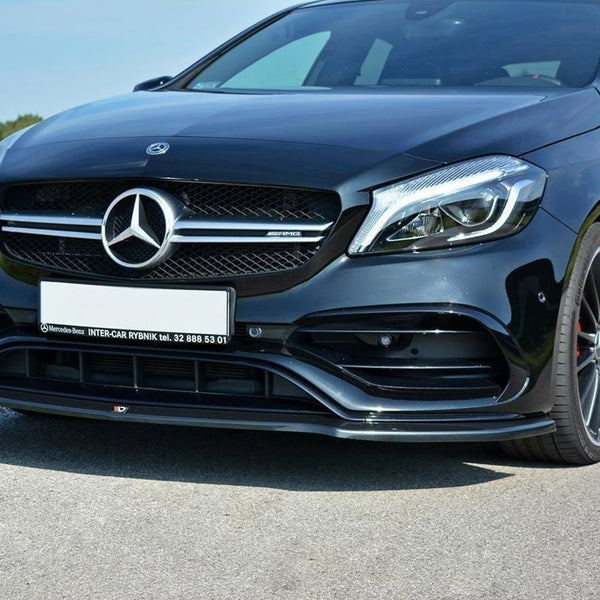A black Mercedes-Benz car is parked on a road, showcasing its sleek front grille and headlights. Text: "Mercedes-Benz INTER-CAR RYBNIK tel. 32 888 53 01." Grassy fields are in the background.
