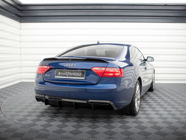 Blue Audi A5 parked in a garage with checkered flooring and white walls. The rear view shows a "#MAXTONIZED" license plate.