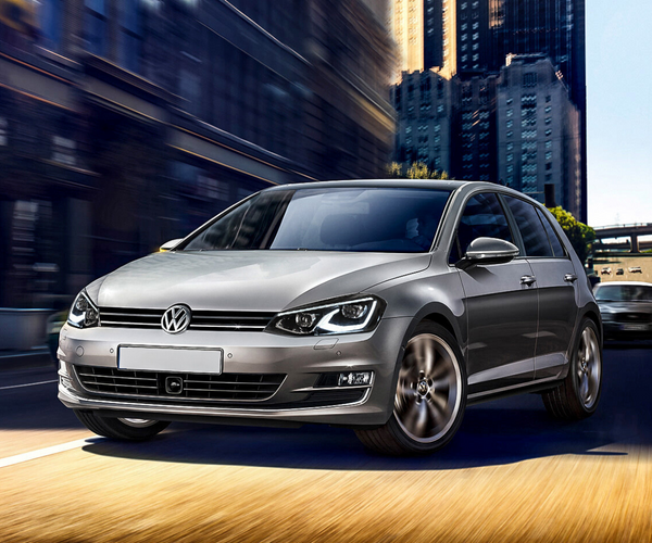A silver Volkswagen car moves swiftly on a road, with blurred city skyscrapers in the background, conveying speed and urban environment.