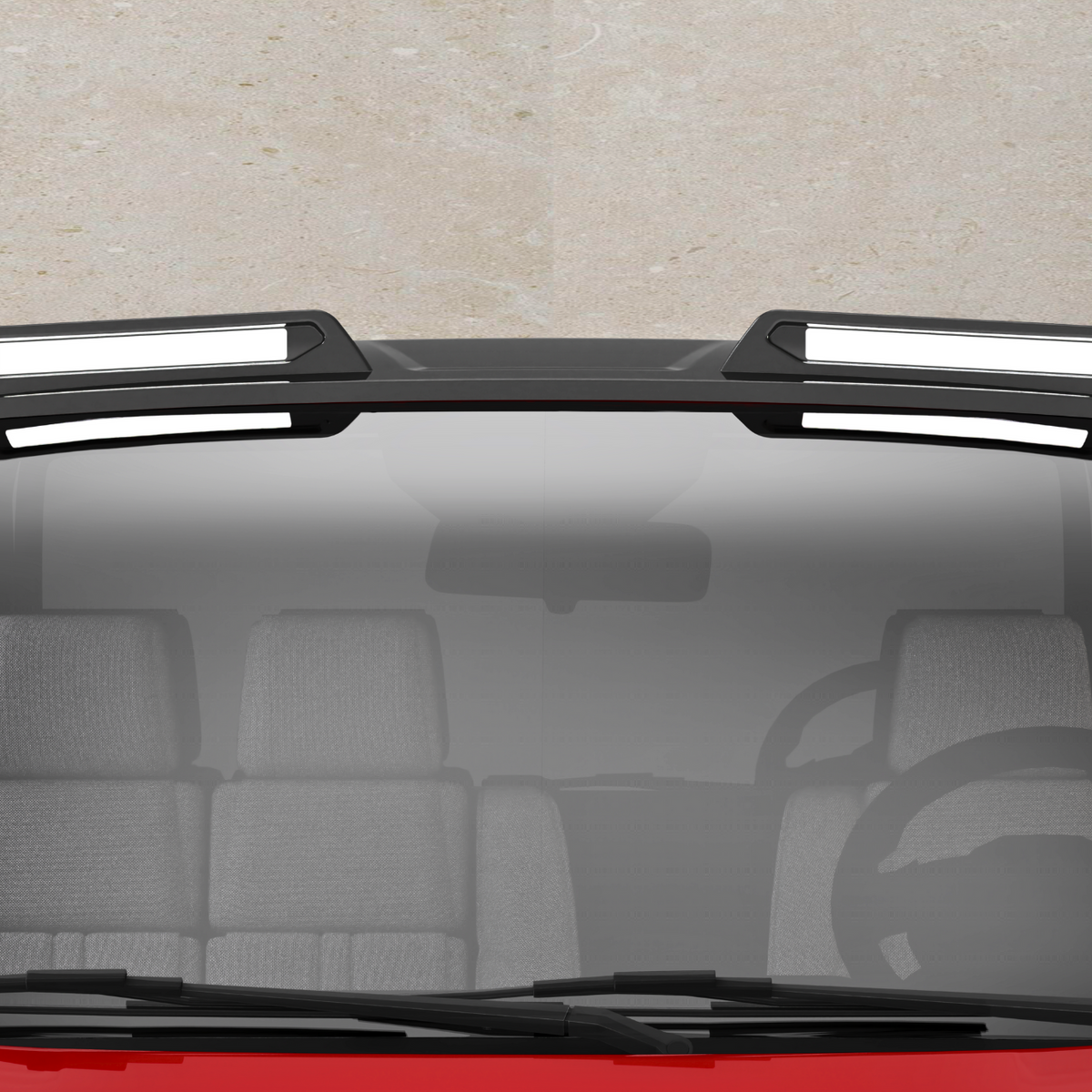 A red vehicle with a black roof features two rectangular, white-highlighted roof racks. The front windshield shows a steering wheel and gray seats inside the car, against a concrete background.