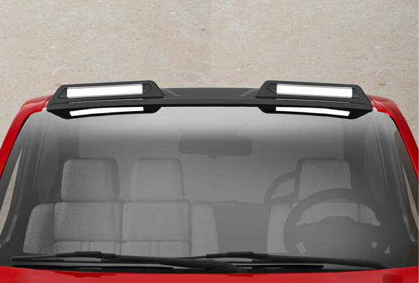 A red vehicle with a black roof features two rectangular, white-highlighted roof racks. The front windshield shows a steering wheel and gray seats inside the car, against a concrete background.