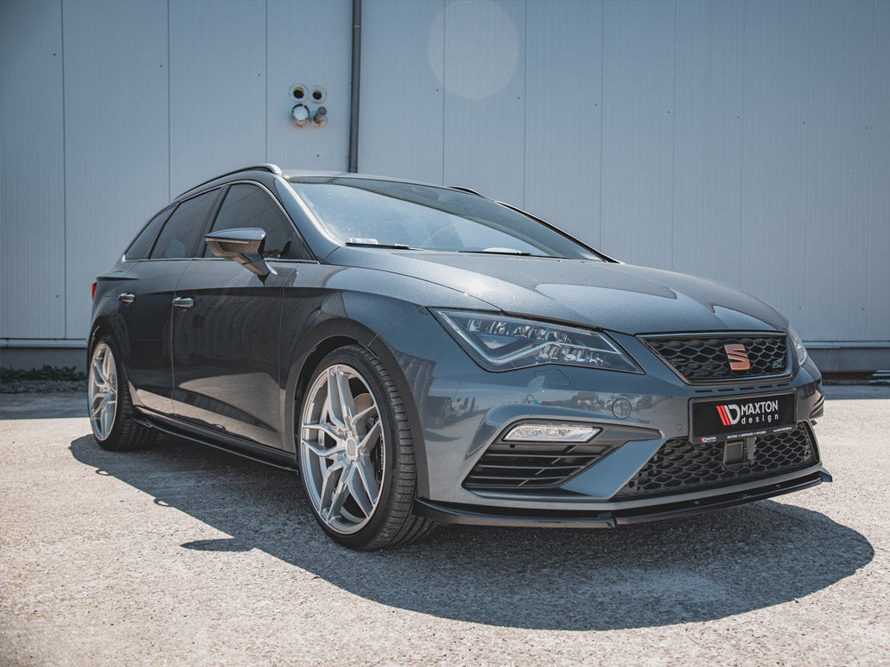 Car parked on a concrete surface, featuring sporty alloy wheels and sleek design. The background is a plain, light-colored building wall. License plate reads "MAXTON design."