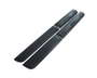Two long, black plastic side skirts, designed for a vehicle, lie parallel on a plain white background. The skirts feature subtle ridges and edges for aerodynamics or aesthetics.