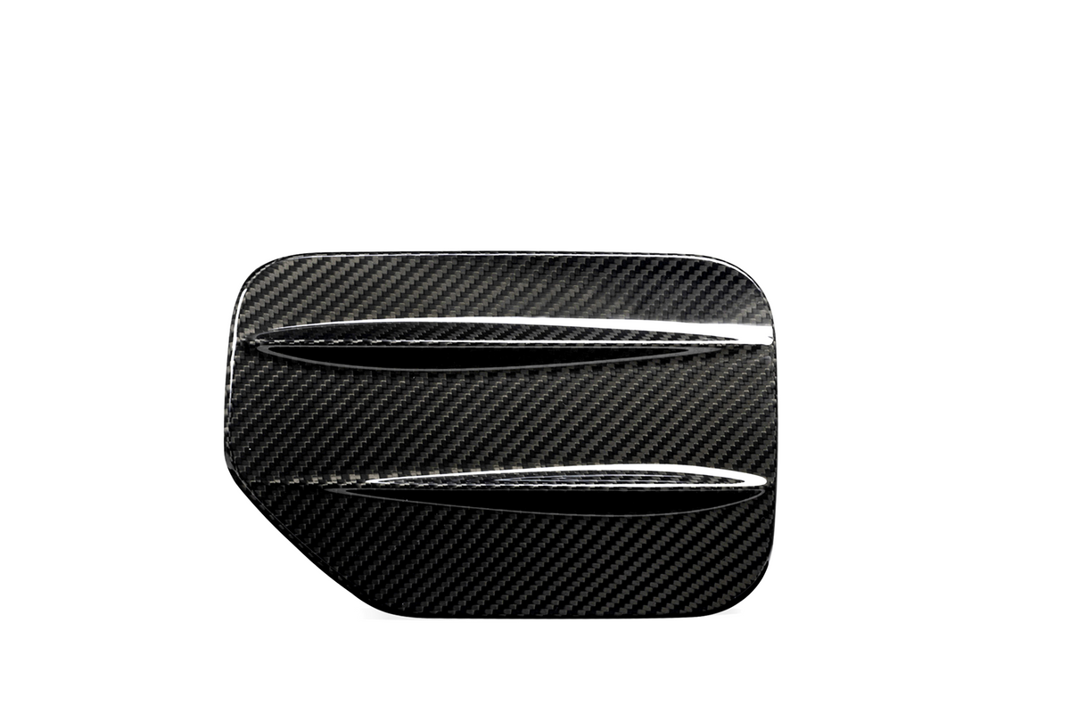 A carbon fiber car part with two horizontal slits, resembling a vent or louver, set against a plain white background.