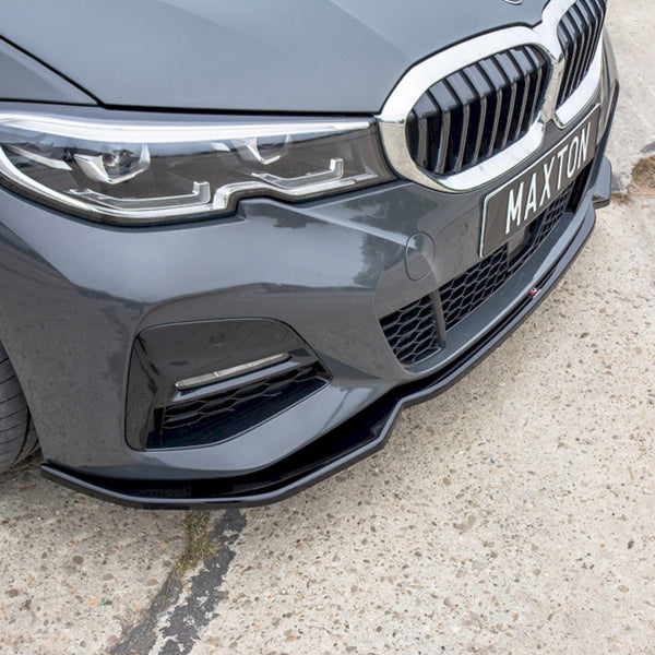 A gray car features a sleek front bumper with dynamic headlights. "MAXTON" is displayed on the license plate. The vehicle is parked on a concrete surface.
