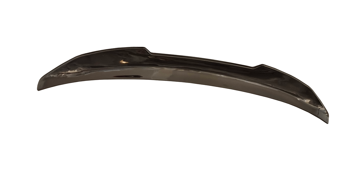 A shiny, curved metal object with a subtle reflective surface, placed against a white background. The object appears smooth and elongated, possibly an automotive or decorative component.