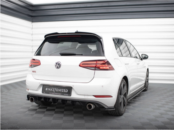 A white Volkswagen GTI is parked on a checkered floor in a bright, industrial-style room. The car has dual exhausts and black wheels. Text: "#MAXTONIZED" on the license plate area.