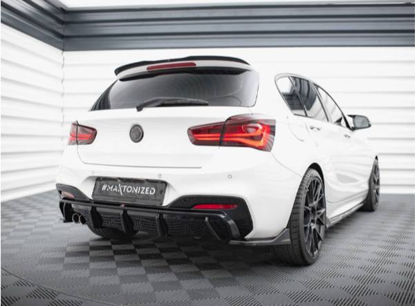 A white, sporty sedan with tinted windows is parked in a modern garage. The car has black alloy wheels, dual exhaust, and a "#MAXTONIZED" license plate on a patterned floor.