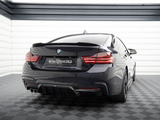 A sleek black BMW is parked in a modern, well-lit garage. The car, seen from the rear, features the text 
