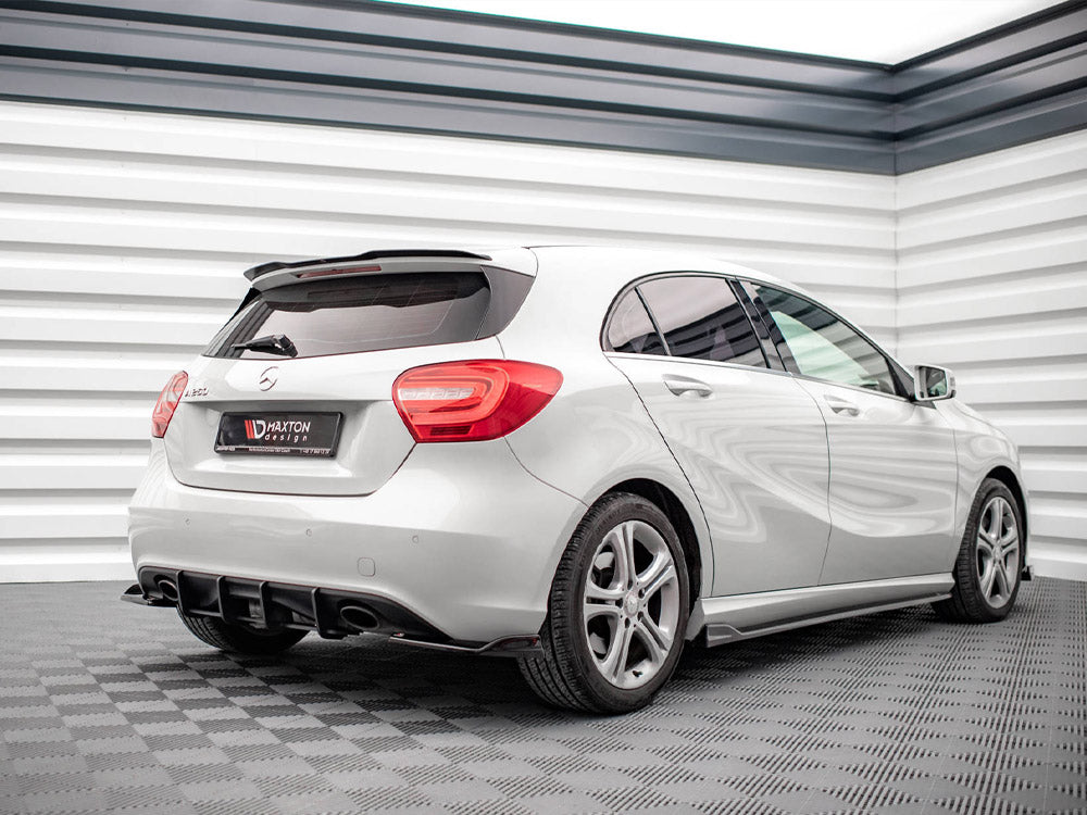 A white hatchback car is parked indoors on a checkered floor. It features red tail lights and a rear spoiler. Visible text on the license plate reads: "MAXTON design."