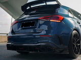 A dark blue Mercedes-AMG A35 car is parked, highlighting its aggressive rear spoiler and quad exhausts. It is positioned under a modern, curved architectural structure.