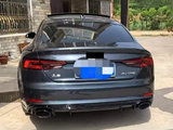 A dark-colored Audi A5 car is parked, rear view showing dual exhausts and 