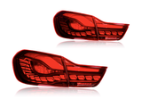 Two red car taillights are placed against a plain white background. The taillights are sleek, featuring intricate patterns and defined sections, reflecting modern automotive design.