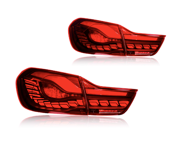 Two red car taillights are placed against a plain white background. The taillights are sleek, featuring intricate patterns and defined sections, reflecting modern automotive design.