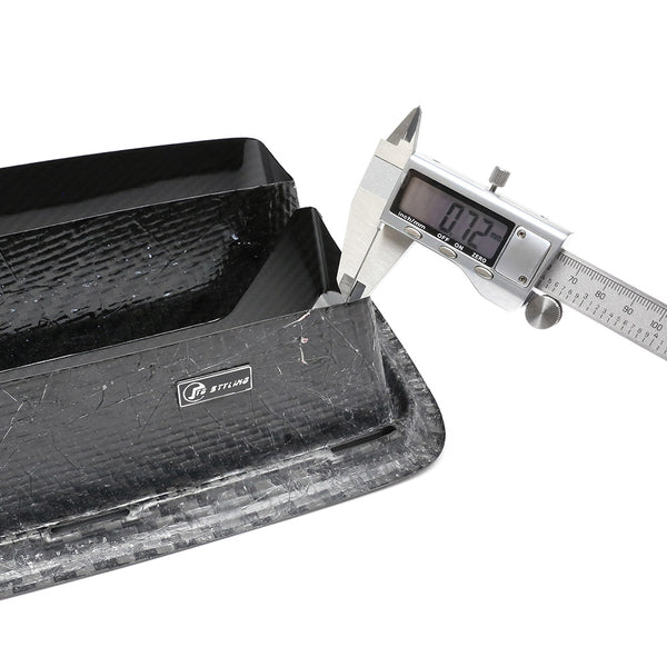 A digital caliper measures the thickness of a black, textured carbon fiber part, displaying "7.37" mm. The part features a label with "STILIND" in a professional setting.