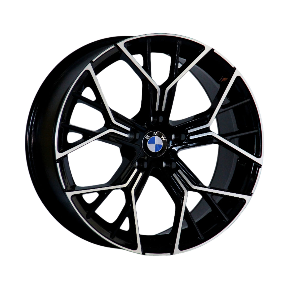A black and metallic car wheel rim features a geometric spoke design, displaying a centrally placed BMW logo. The rim is isolated on a white background.