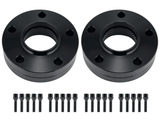 Two black circular wheel spacers, each with five bolt holes, lie side by side. Below, twenty matching black bolts are lined up in two rows on a white background.