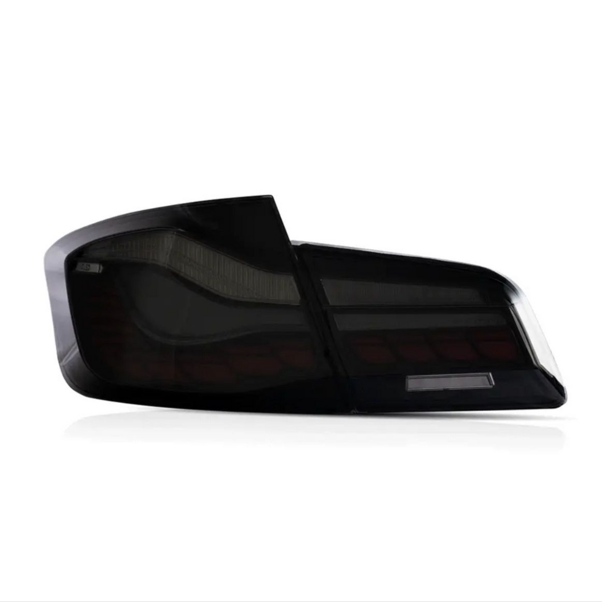 A sleek, dark-tinted car tail light is displayed against a white background, showcasing its angular design and reflective surface.