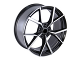A black and silver alloy wheel with angular, geometric spokes, positioned at an angle against a plain white background.