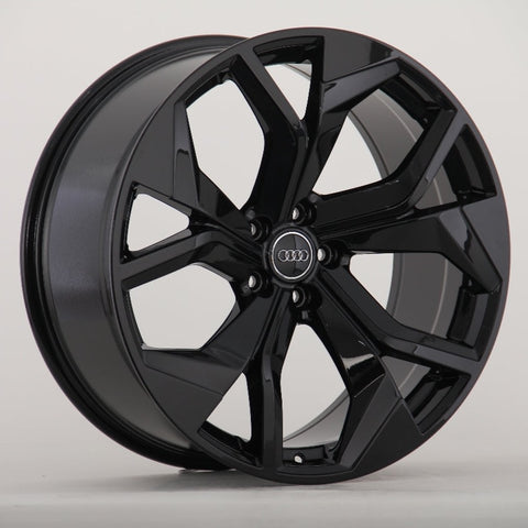 A glossy black alloy wheel with a seven-spoke design prominently displays an Audi logo at its center, positioned against a plain, neutral background.