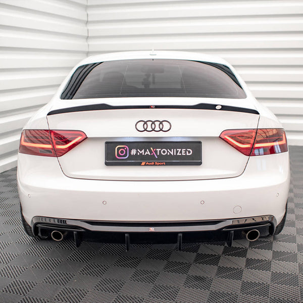 White car parked in a grid-patterned room, highlighted by the rear view with red taillights and dual exhausts. License plate reads "#MAXTONIZED Audi Sport" with an Instagram logo.